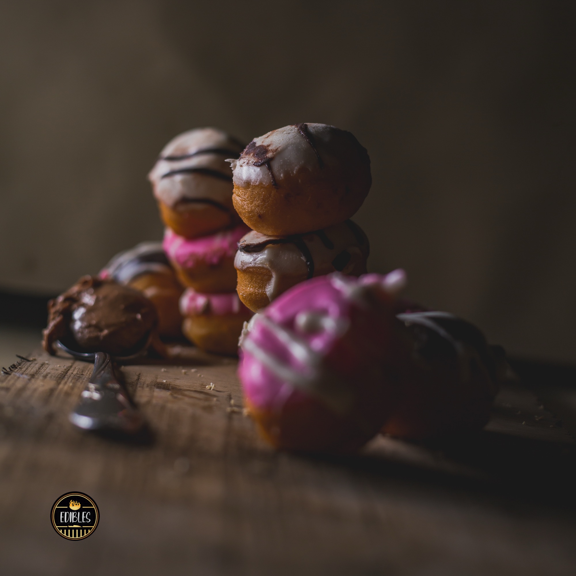 Stack of colourful glazed mochi-style pastries on a wooden surface