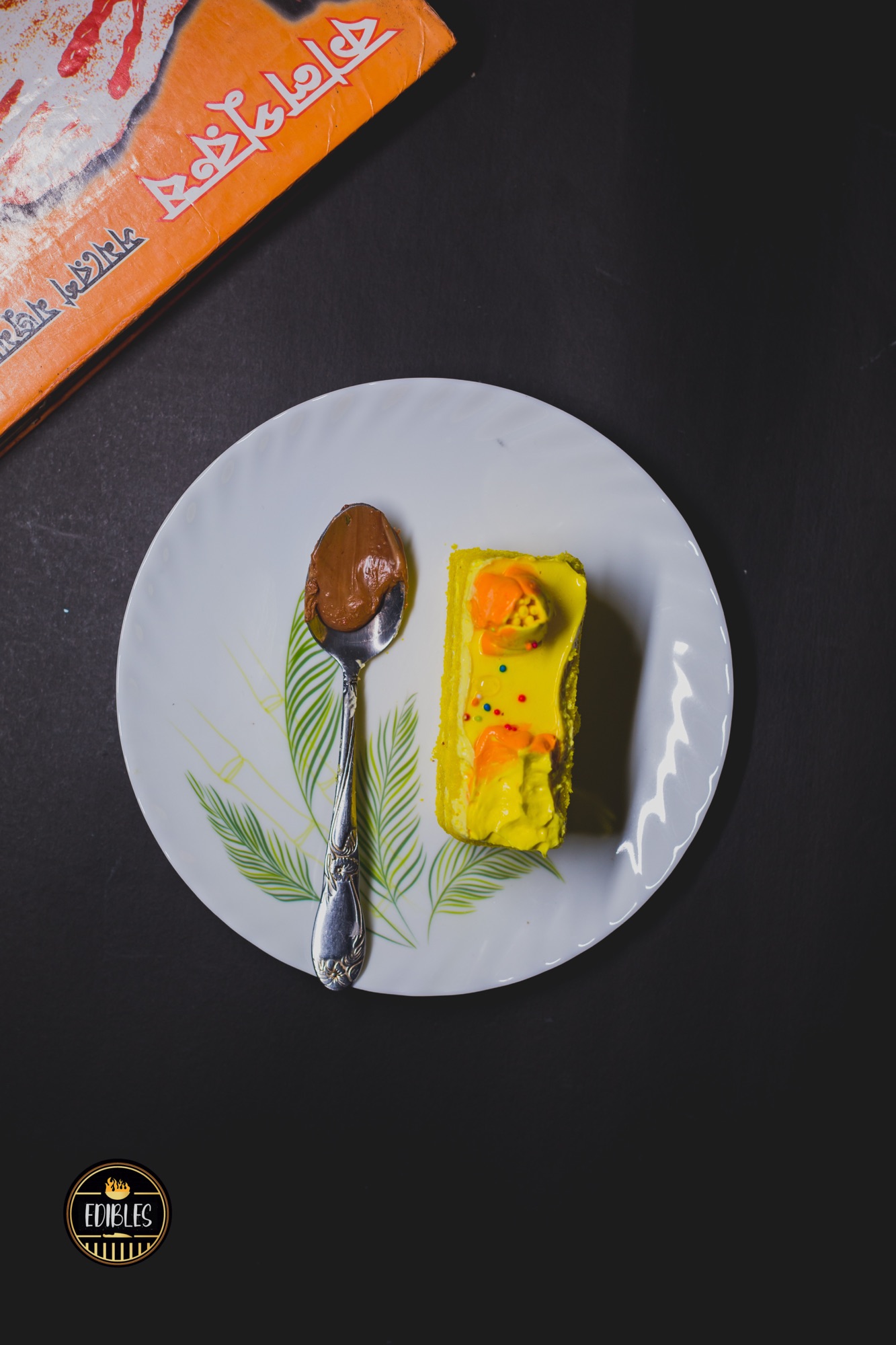 Overhead dessert slice with glossy custard sauce and mint, served with a spoon