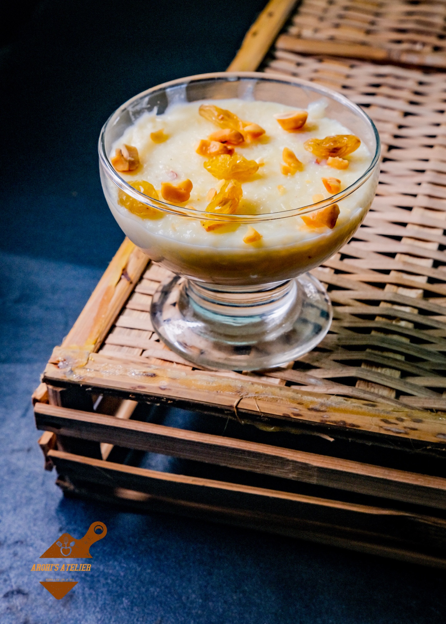 Glass of mishti doi (sweet yogurt) topped with nuts on a wooden crate