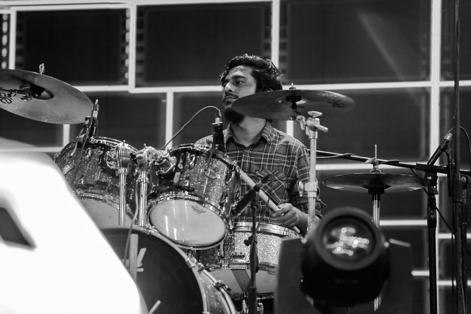 Drummer mid-performance behind a glittering kit, black-and-white concert photo from Dhaka — Sayeed BM