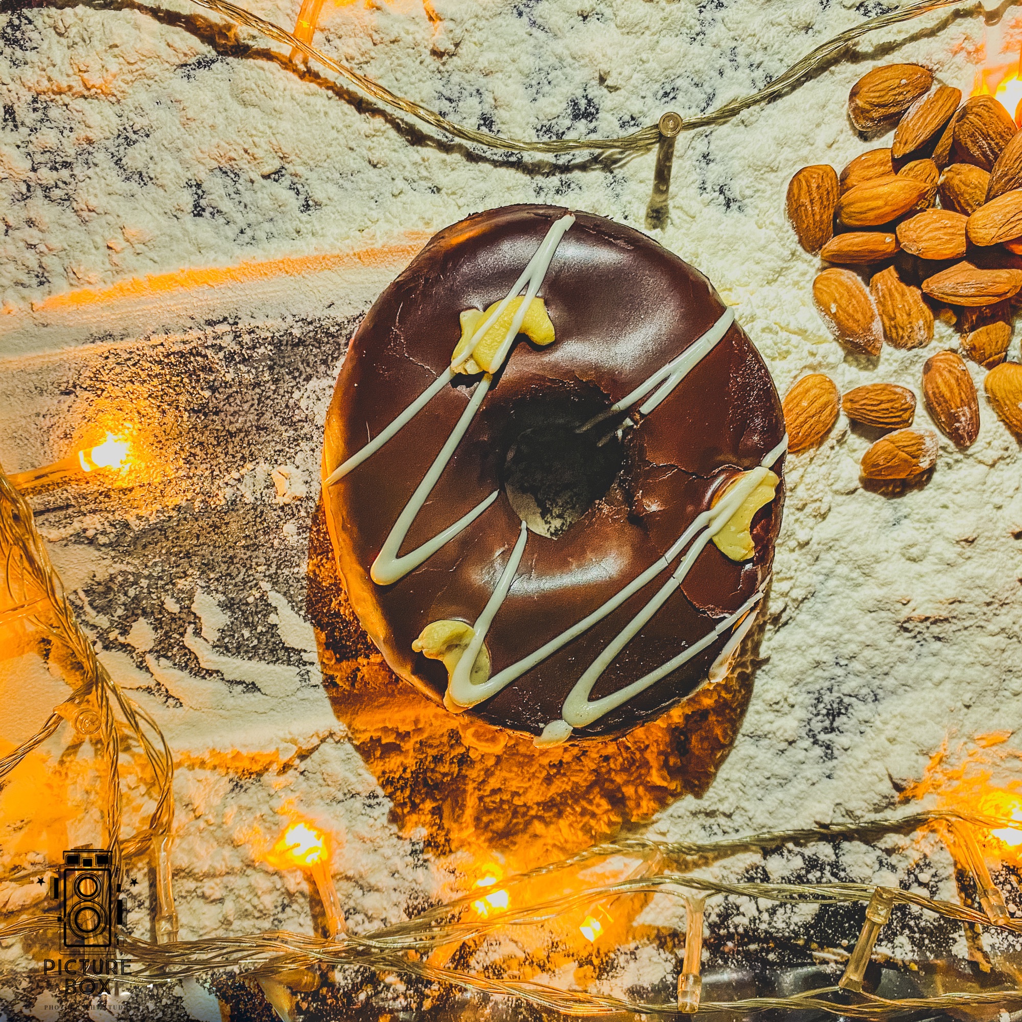 Chocolate-glazed donut with almonds, macro shot on a marble surface