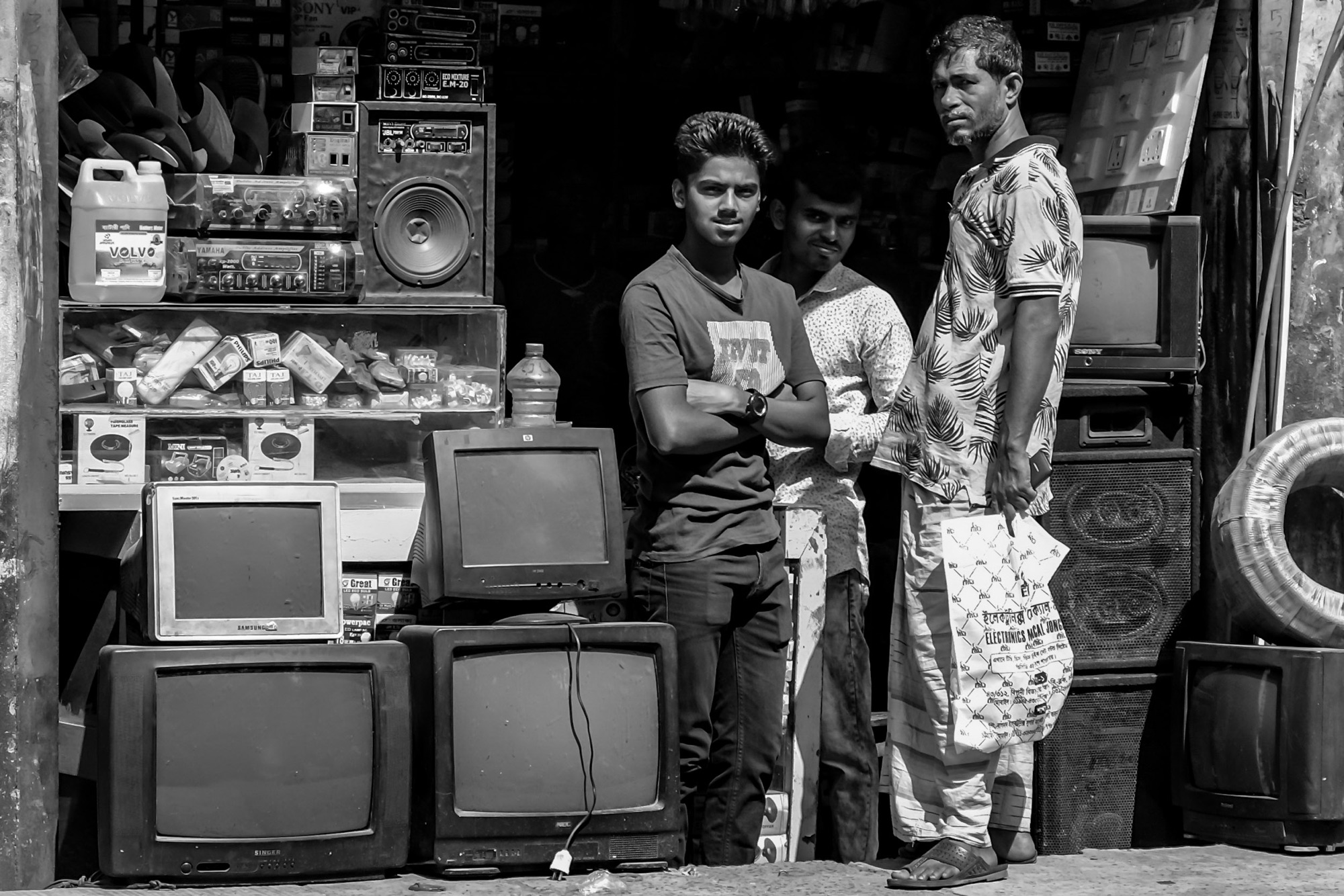Two young men with a large radio/speaker on a Dhaka street, black and white portrait