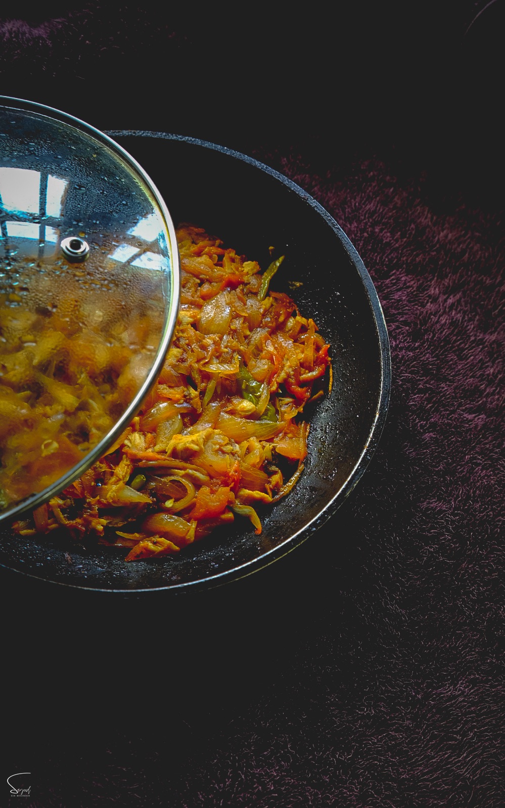 Wok of sizzling stir-fried vegetables and chicken captured mid-toss in a restaurant kitchen