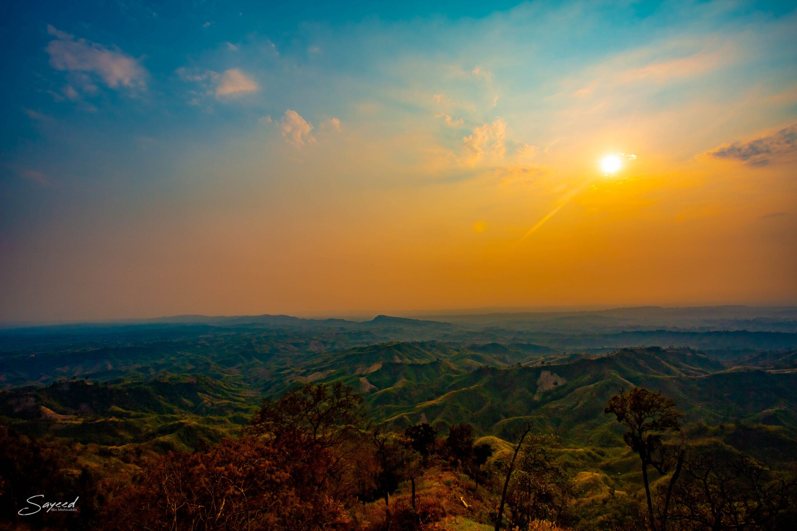 The sun setting over layered mountain ridges in the Chittagong Hill Tracts, Bangladesh