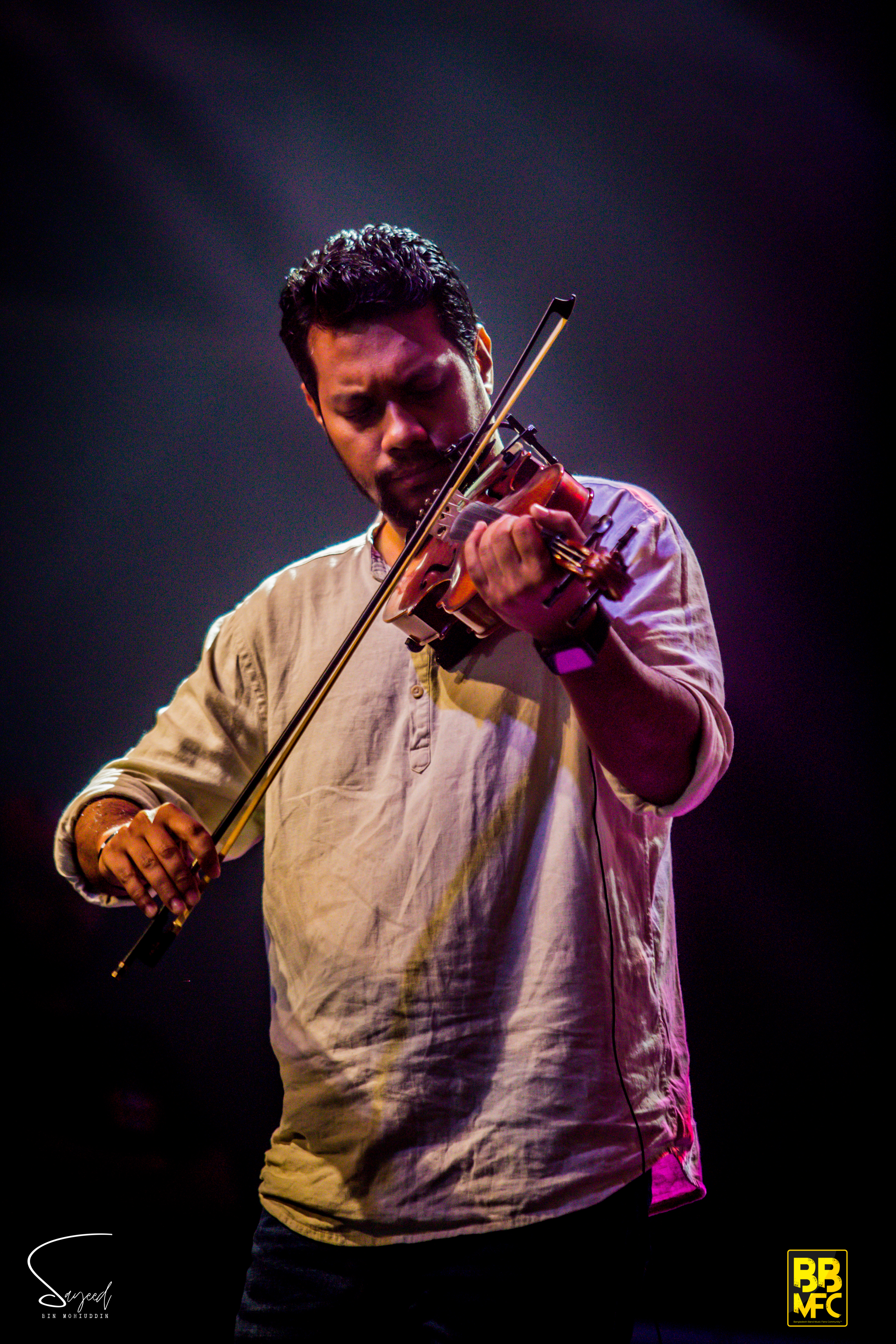 Performer under colorful stage light at a Shironamhin concert in Dhaka — Sayeed BM