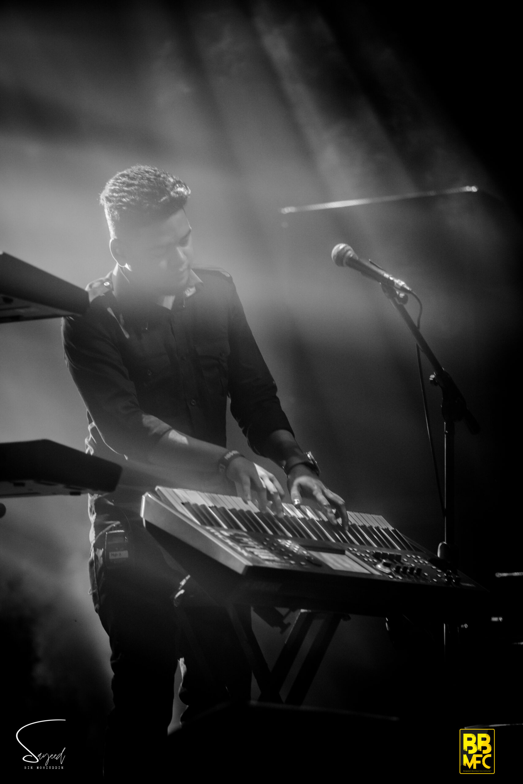 Keyboardist playing under hazy backlit stage smoke, black-and-white concert photo from Dhaka — Sayeed BM
