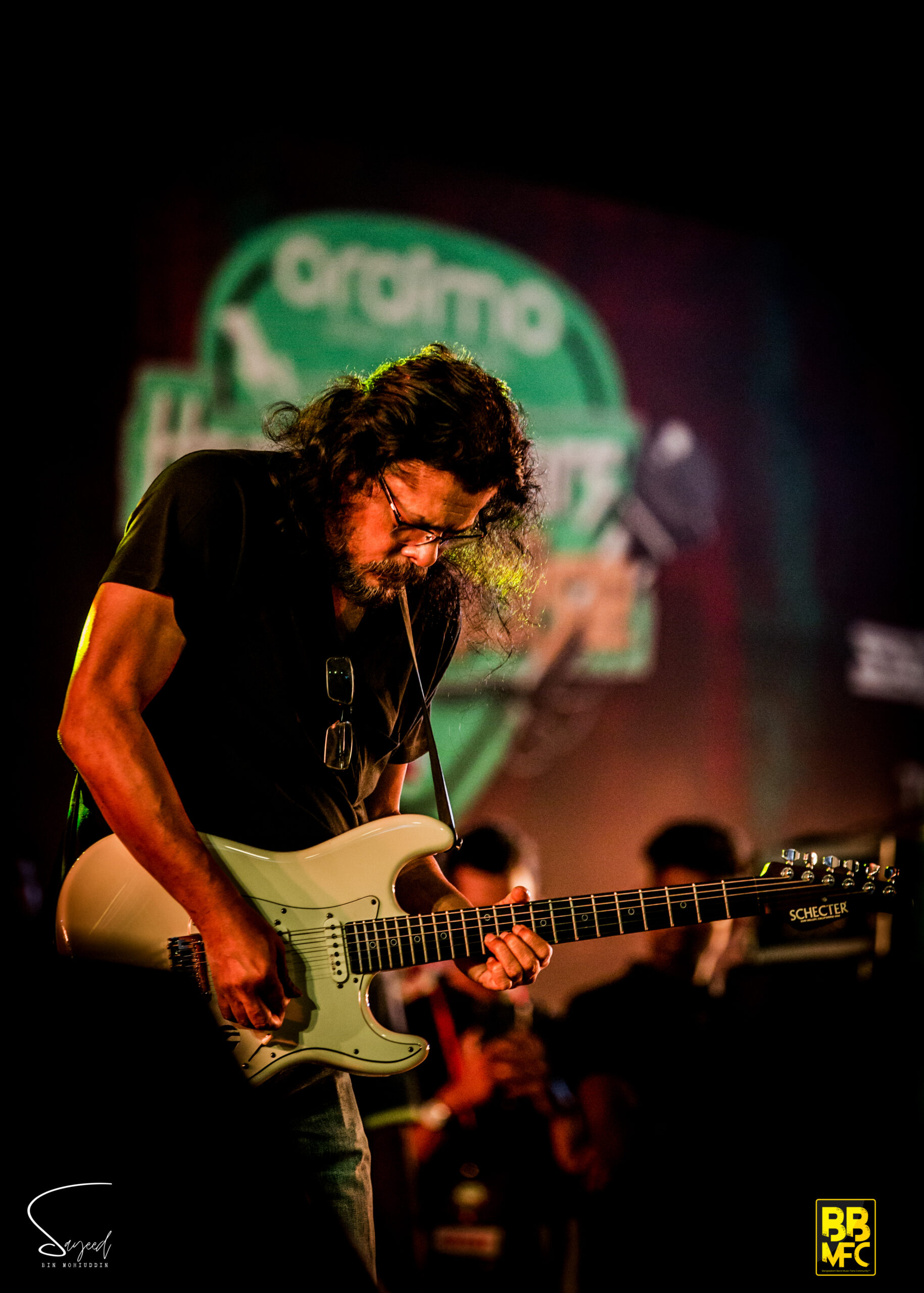 Long-haired guitarist bent over his white Stratocaster, black-and-white concert photo from Dhaka — Sayeed BM