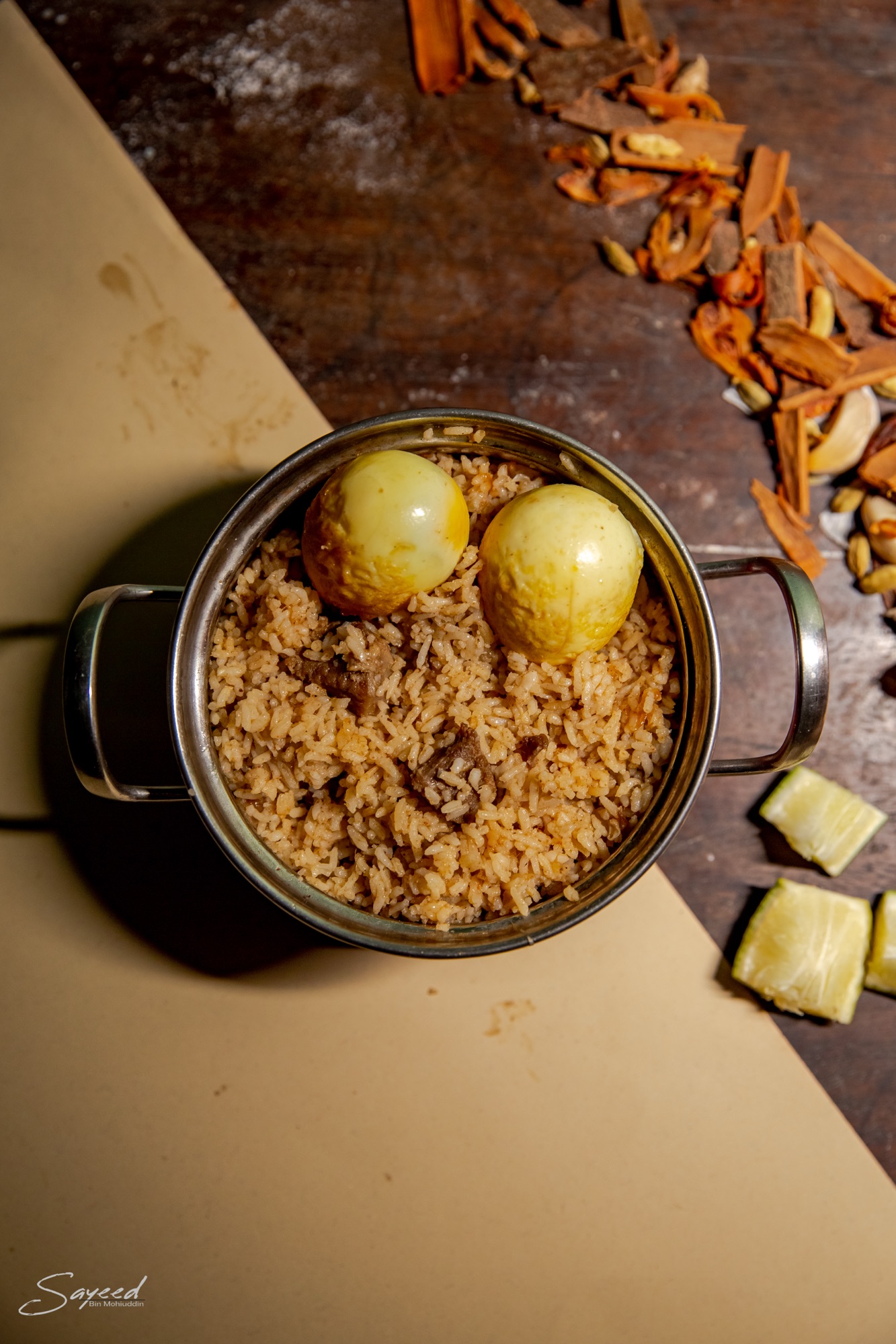 Overhead shot of a pot of biryani rice with whole spices, ready to serve