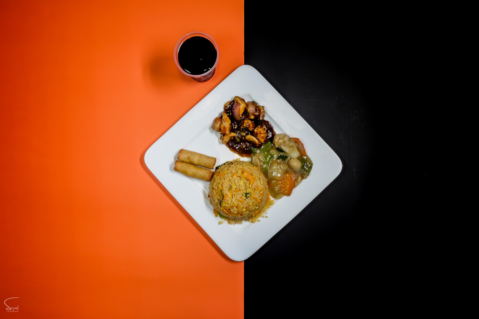 Overhead shot of a diamond-shaped platter with mixed appetizers on a bold orange and black background