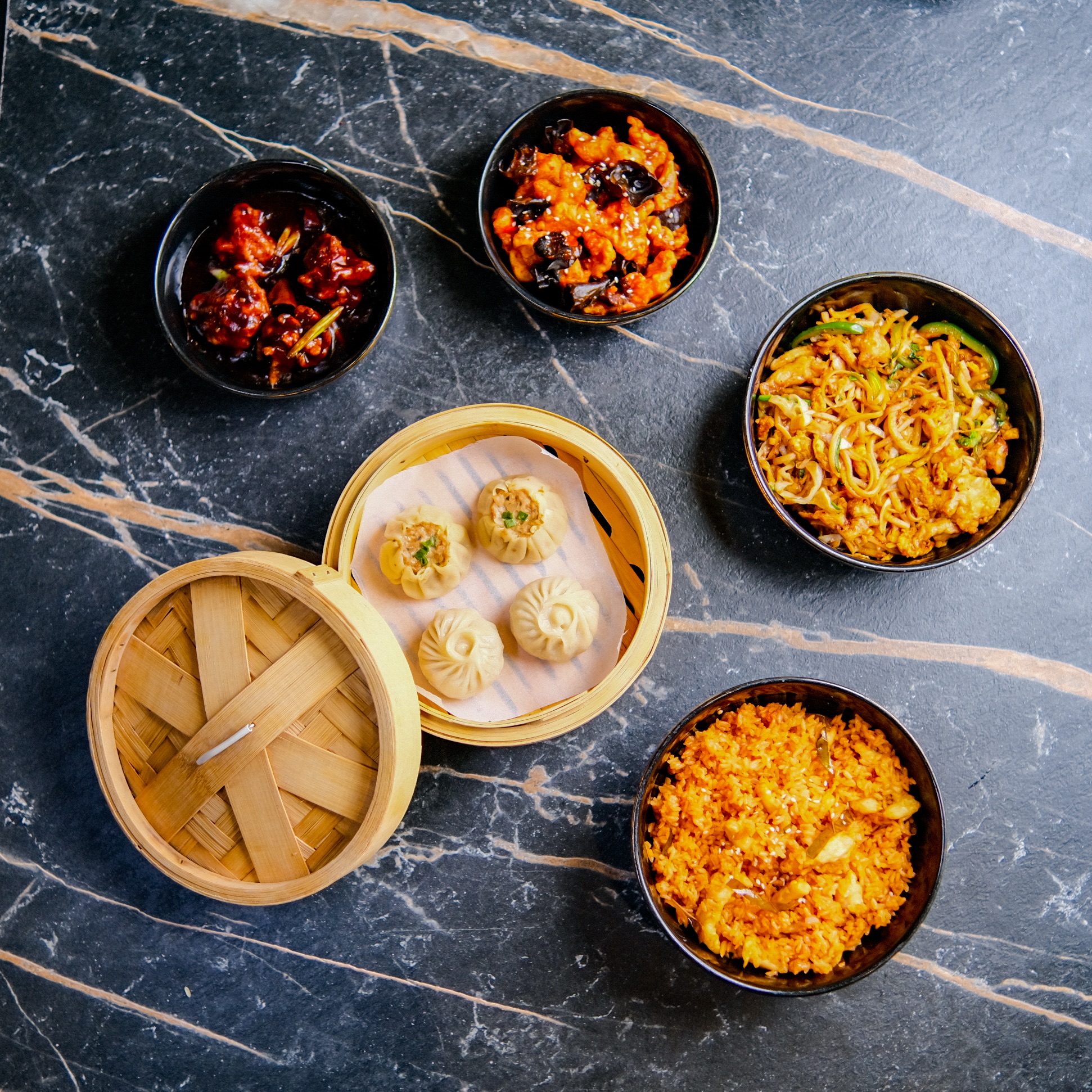 Overhead bowls of fried rice and chili dipping sauce on a dark background