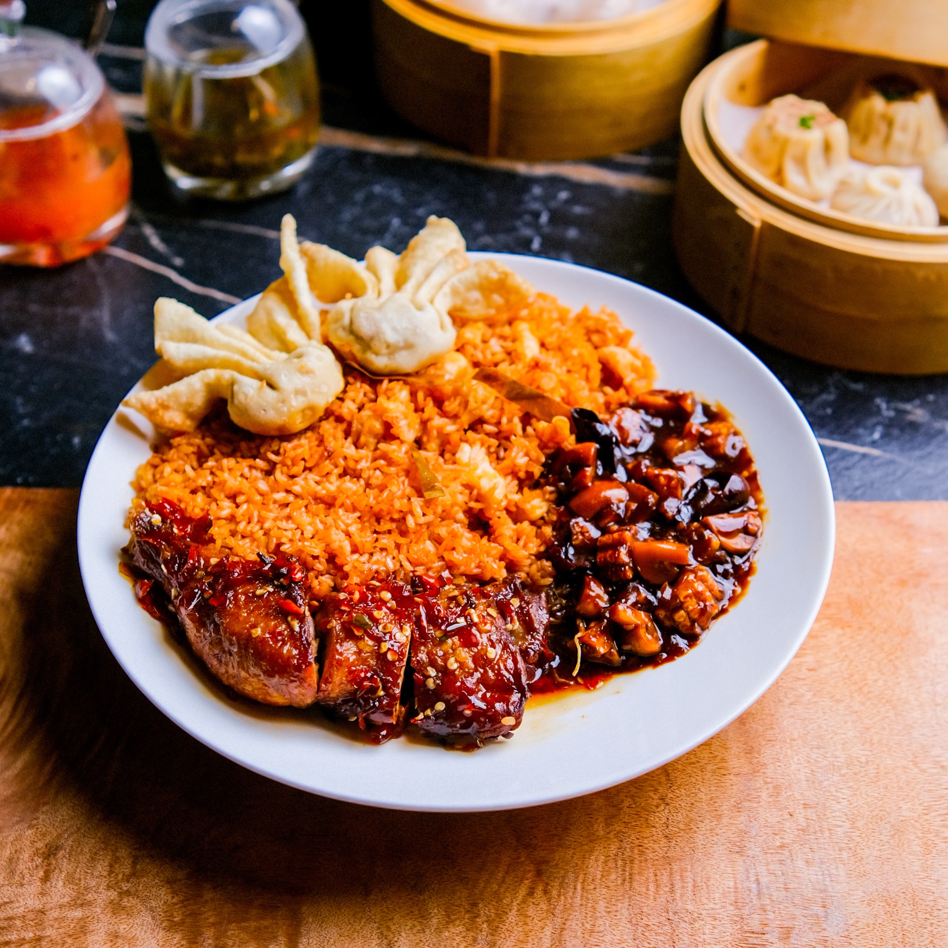 Split-background plate of dumplings and fried chicken, half orange half dark