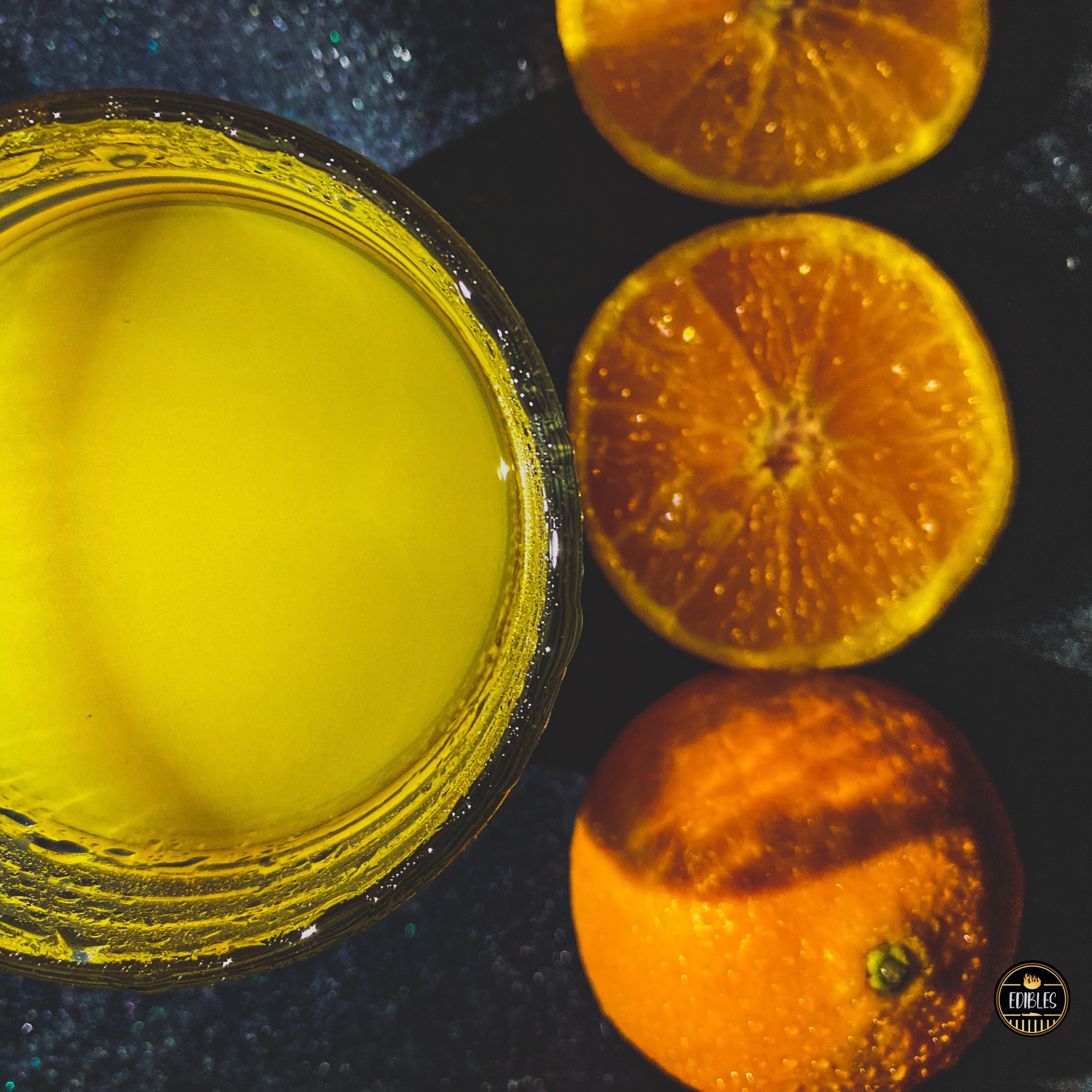 Close-up of a glass of fresh orange juice with orange slices, dramatic side light