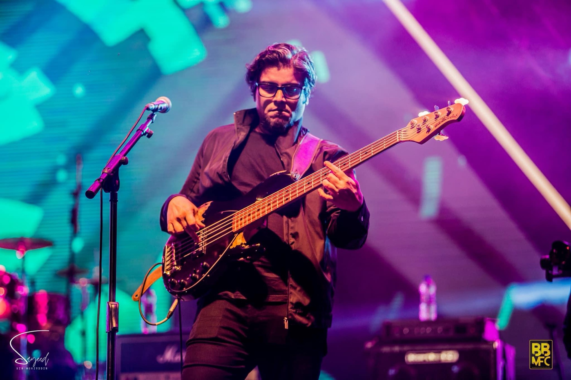 Performer mid-performance under stage light at a Shironamhin concert in Dhaka — Sayeed BM