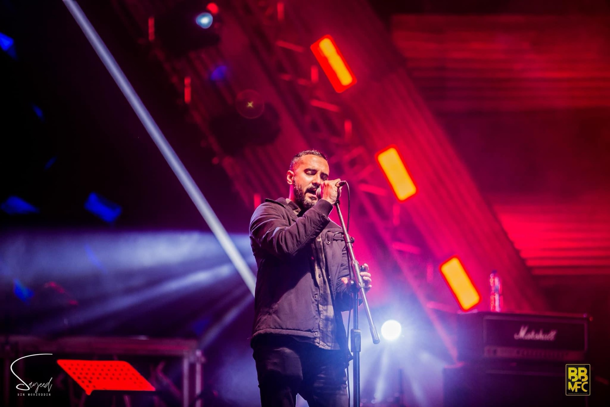 Performer on stage under stage light at a Shironamhin concert in Dhaka — Sayeed BM