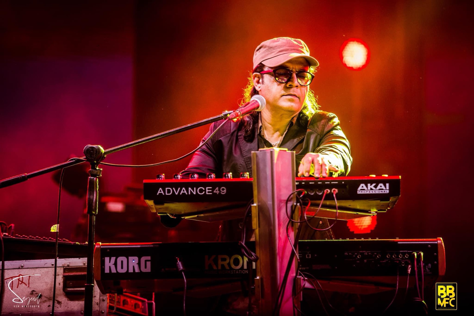 Performer mid-song under colorful stage light at a Shironamhin concert in Dhaka — Sayeed BM