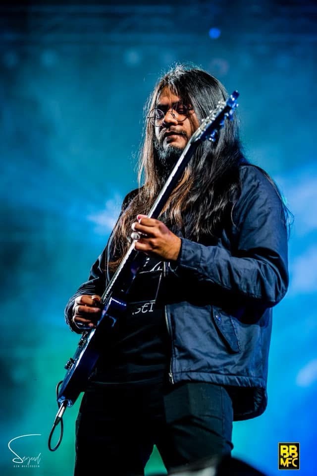 Performer on stage under stage light at a Shironamhin concert in Dhaka — Sayeed BM