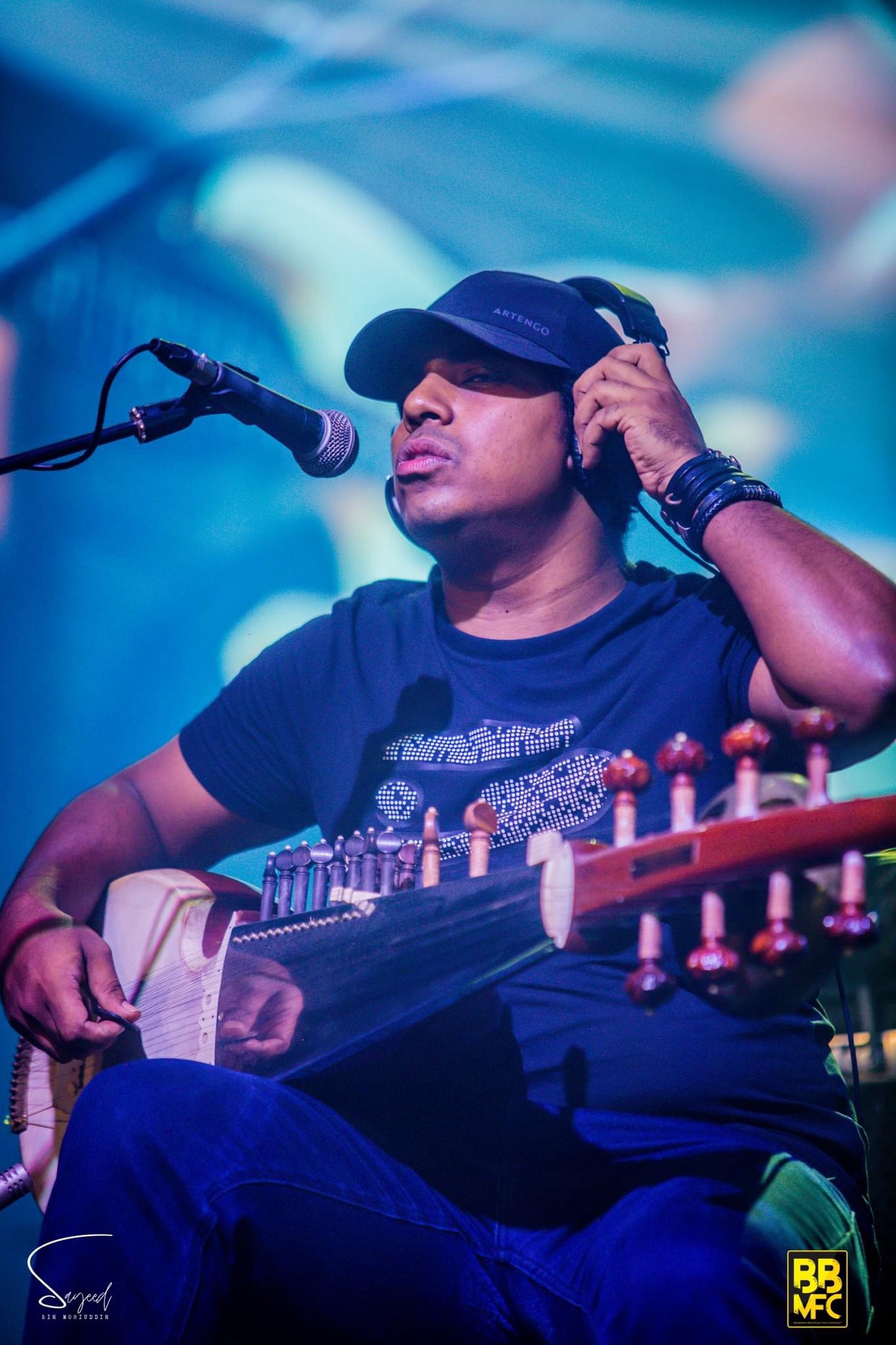 Performer on stage under stage light at a Shironamhin concert in Dhaka — Sayeed BM