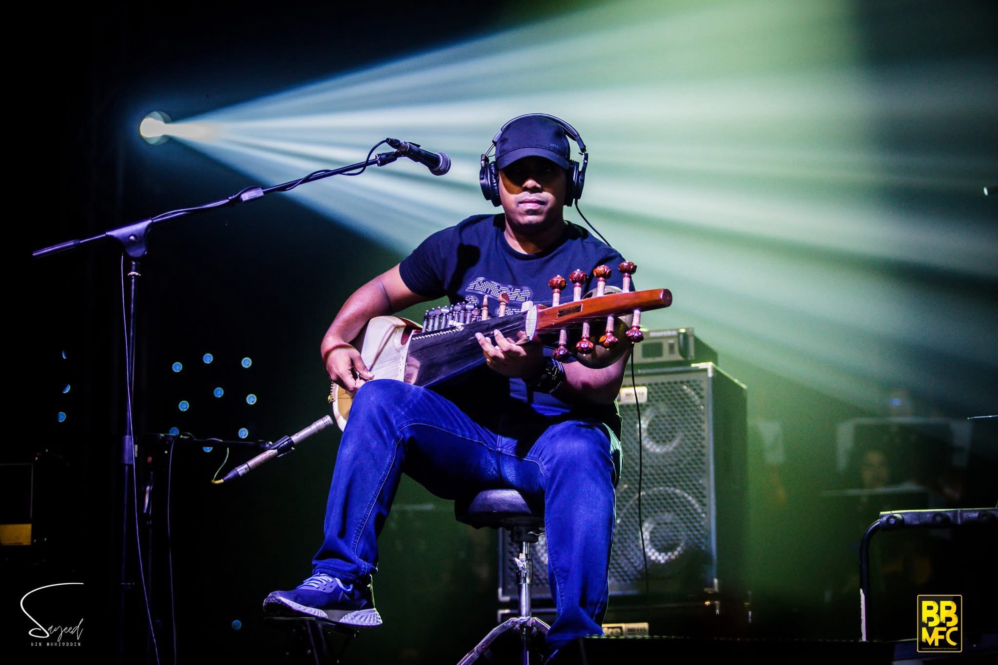 Performer on stage under stage light at a Shironamhin concert in Dhaka — Sayeed BM