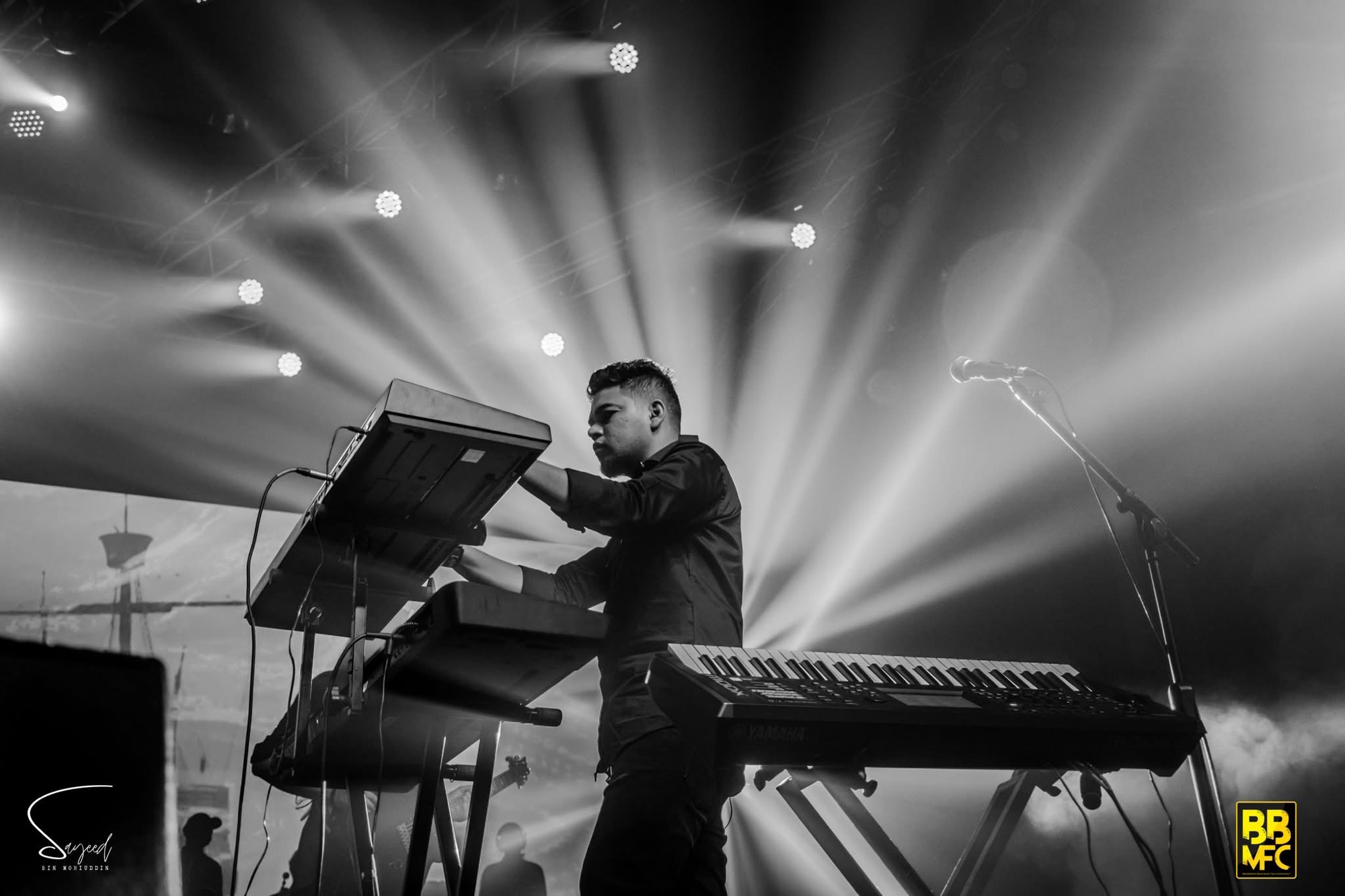 Performer mid-performance under stage light at a Shironamhin concert in Dhaka — Sayeed BM