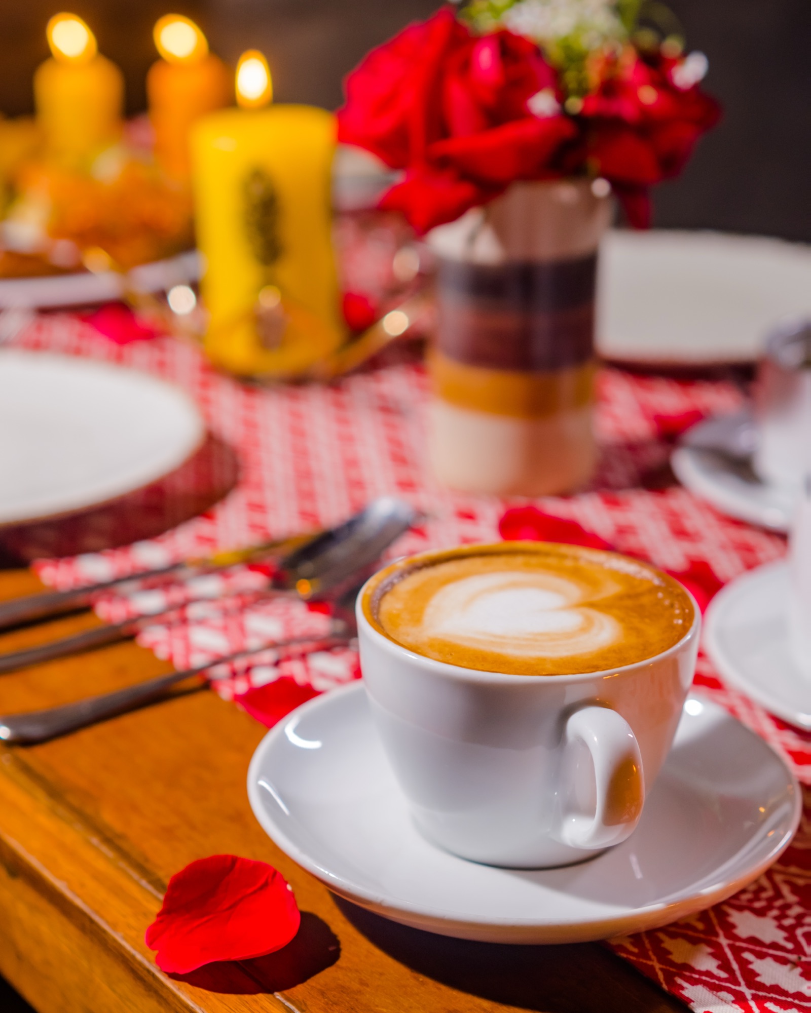 Cappuccino with latte art served on a red checked cafe tablecloth