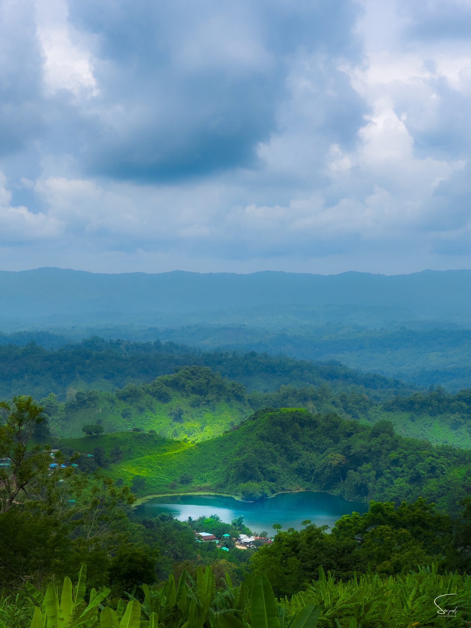 Boga Lake cradled in green hills under dramatic cloud, Bandarban